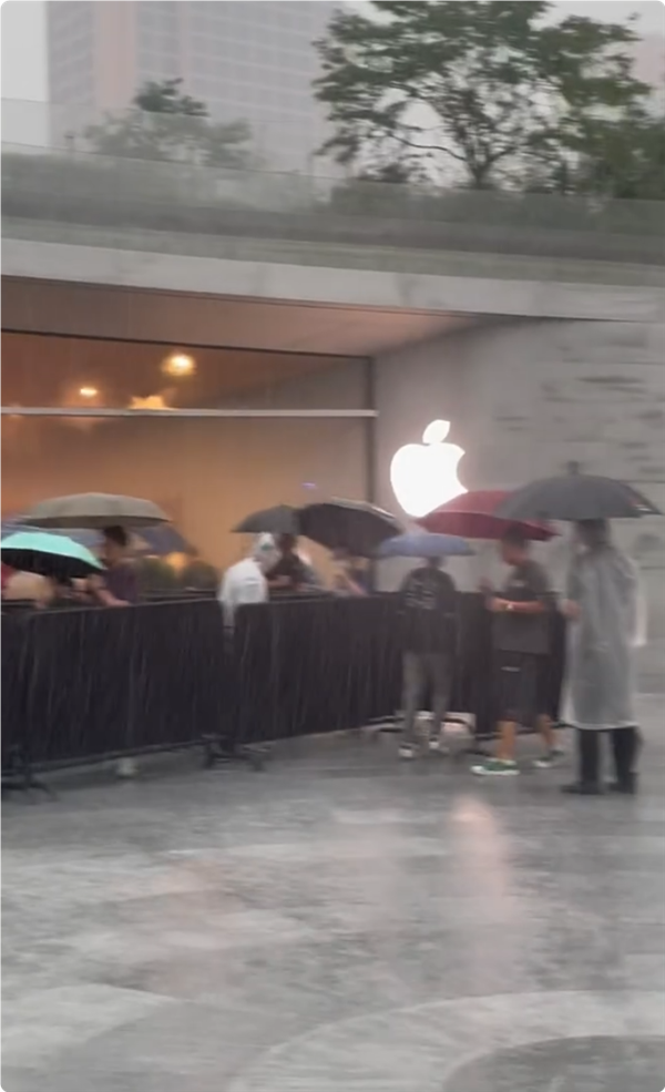 首批iPhone 16用戶收到新機(jī)：果粉暴雨中在Apple Store排長隊(duì)取貨